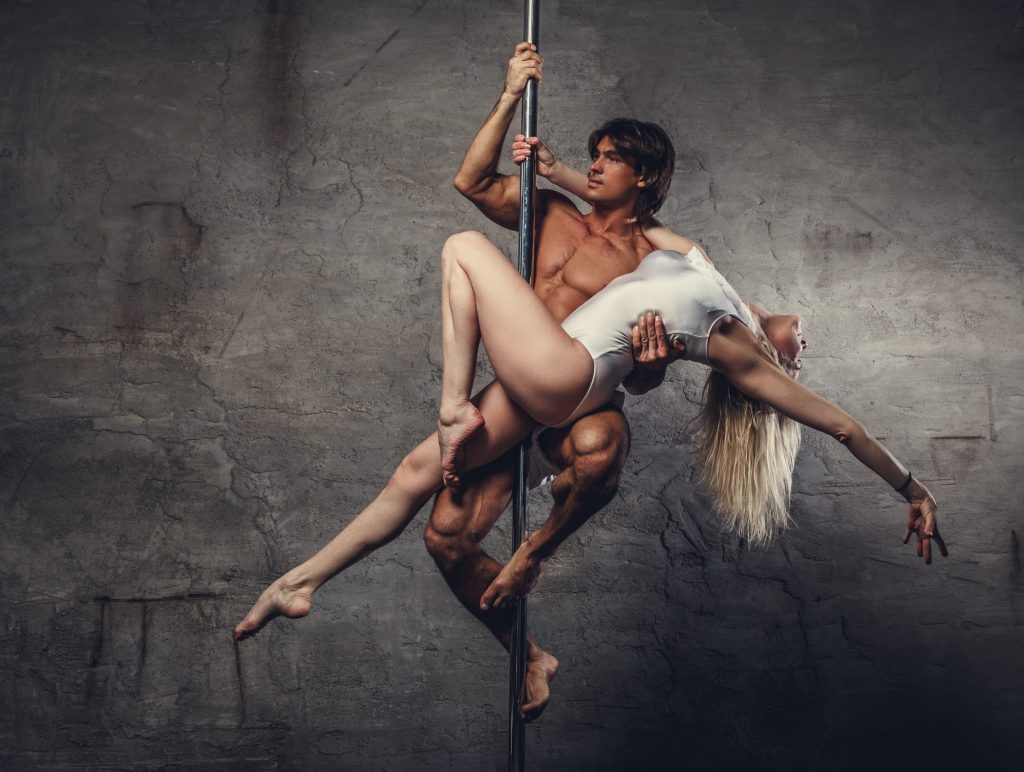 Couple in air on a pole dance stand.